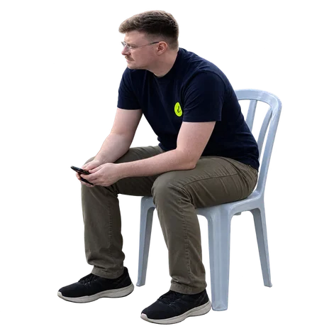 Igal leaning forward in a chair, holding his phone.